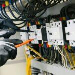 Electrician testing electrical panel with multimeter